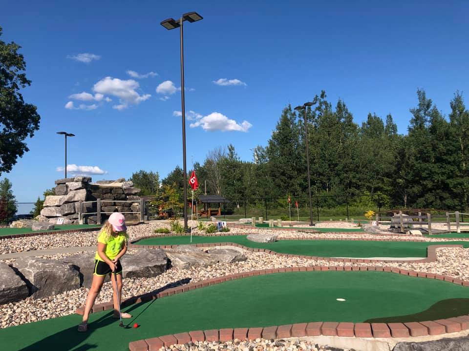 A girl is playing mini-golf in Blackbird Falls Mini Putt