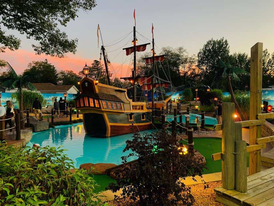 Mini golf fairways designed with a ship in the lake in Skull Island Miniature Golf