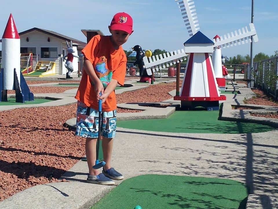 A boy is playing mini putt in Wasaga 500 Mini Golf club